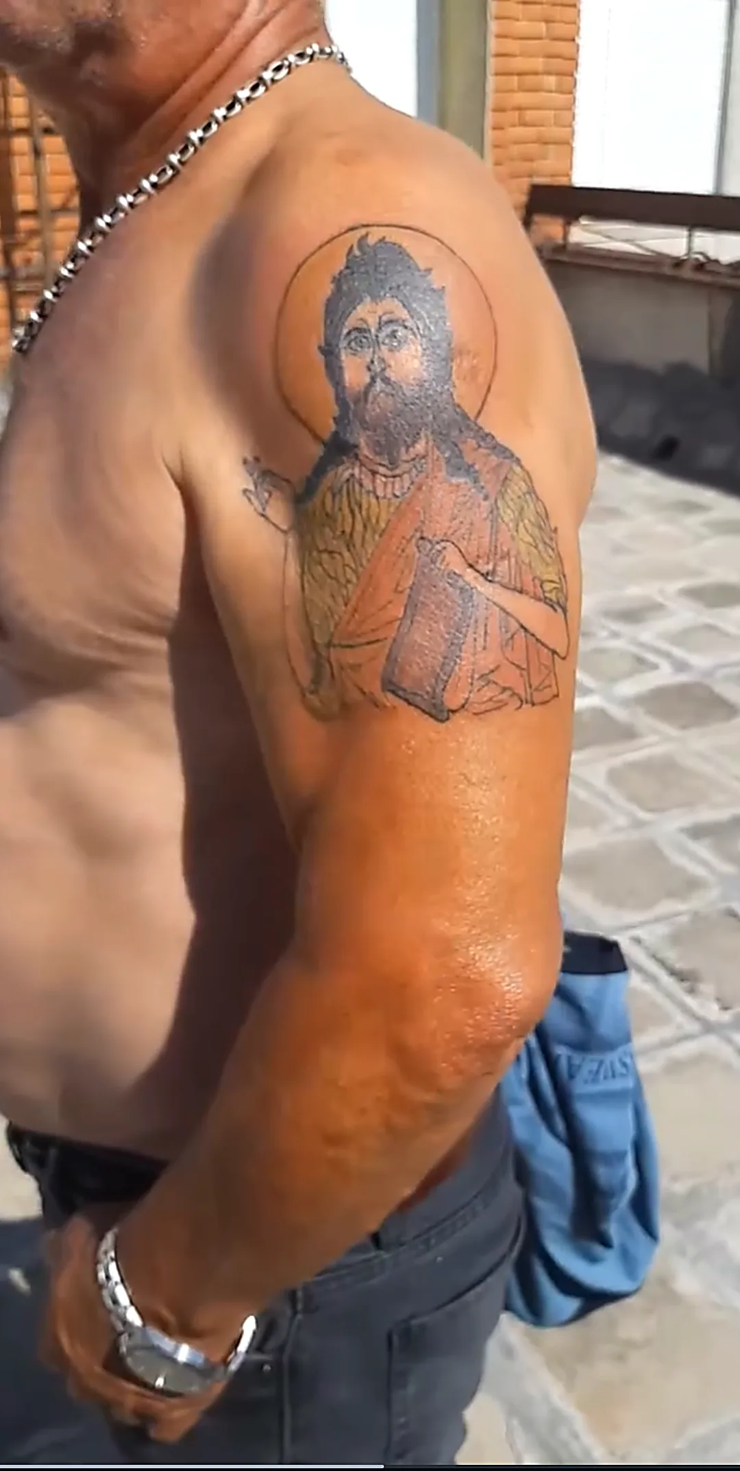 Kolor tetovaža svetačkog portreta na ramenu.